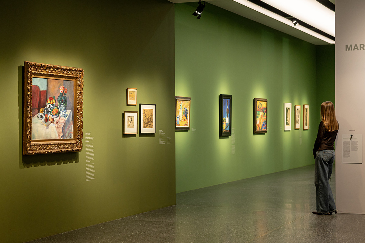 Auf dem Bild sieht man eine Person vor Werken in der Ausstellung Von Monet bis Picasso. Jüdische Kunstsammler:innen in Deutschland.