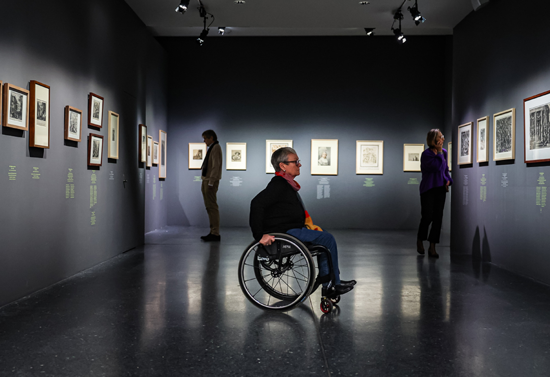 Rollstuhlfahrende Person in der Ausstellung