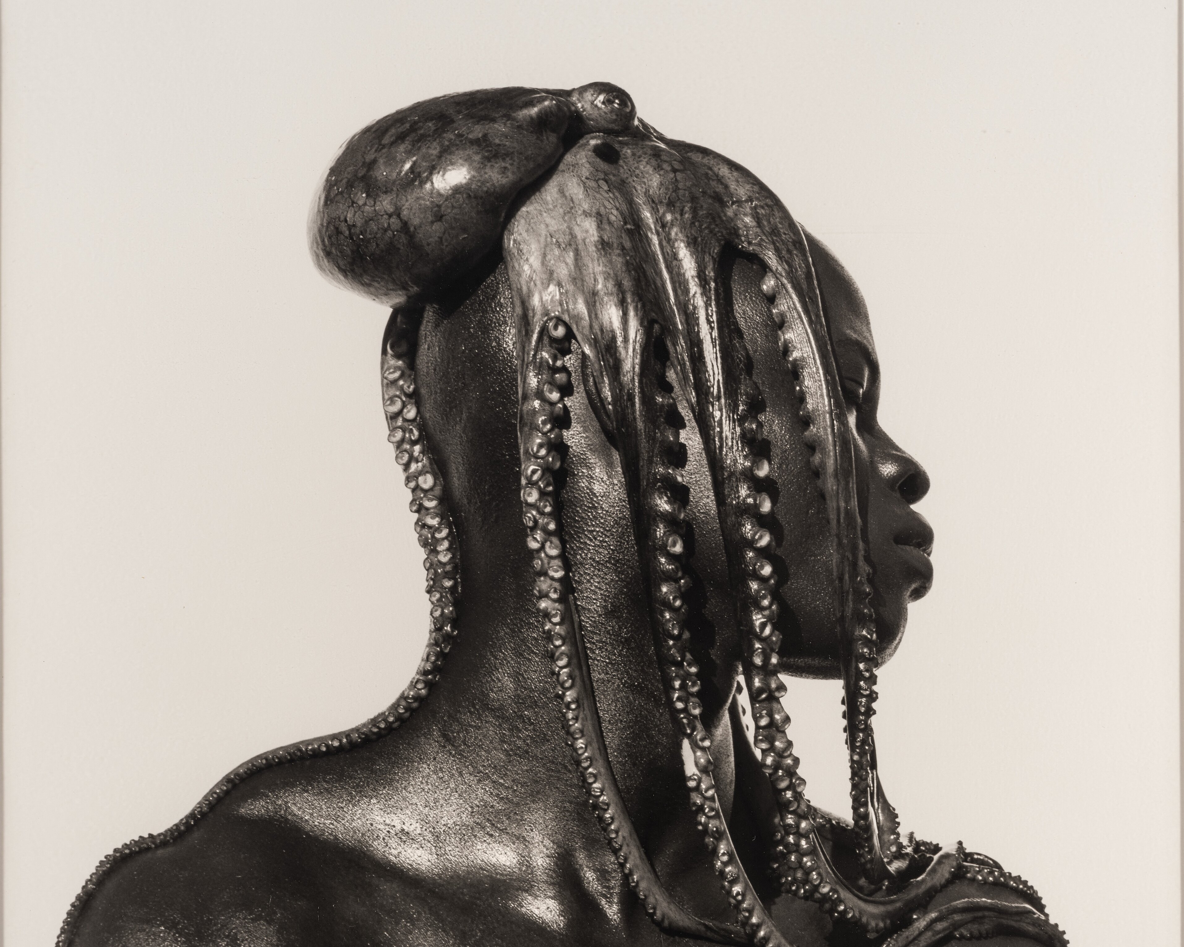 Das Werk von Herb Ritts zeigt einen Mann in der Seitenansicht, der einen Oktopus auf dem Kopf trägt.